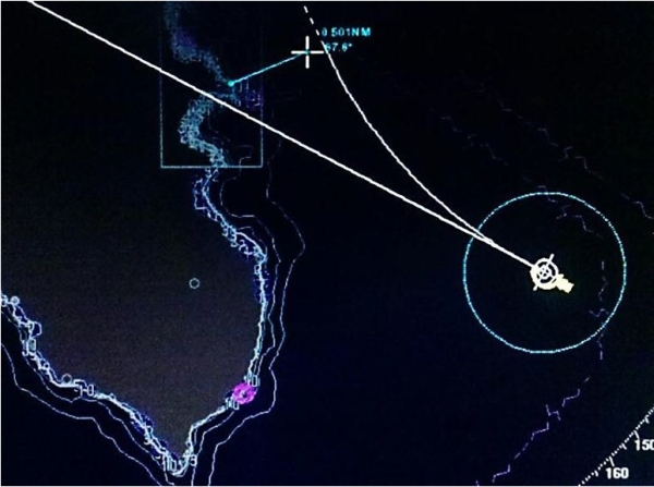 Abb. 08: Simulation des IMO Marine Safety Commitee (MSC). Die durch den SOOW geforderte Kurskorrektur hätte um 21:37 erfolgen müssen, um das Schiff in einem Radius von 2NM bei einer Geschwindigkeit von 15,4 Knoten in einem Abstand von 0,5 NM (also wie geplant) an der Insel Giglio vorbei zu führen. Die gebogene Kurslinie stellt den hypothetischen Kurs der eingeleiteten Kurve dar. Die gerade Linie zeigt den momentanen Kurs des Schiffes um 21:37. Der Kreis symbolisiert den 0,5NM Sicherheitsring.